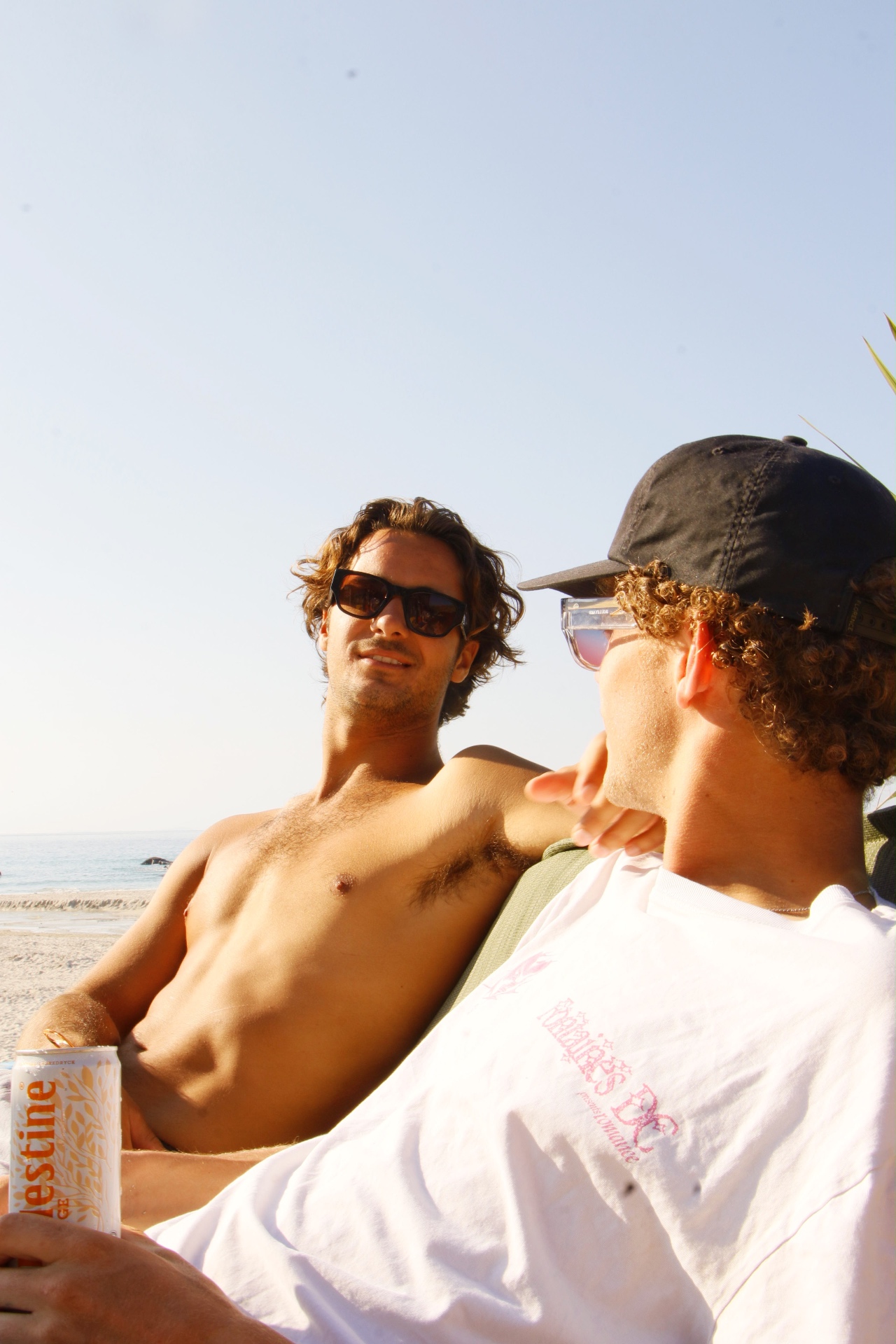 Two friends relaxing on the beach in the evening sunshine