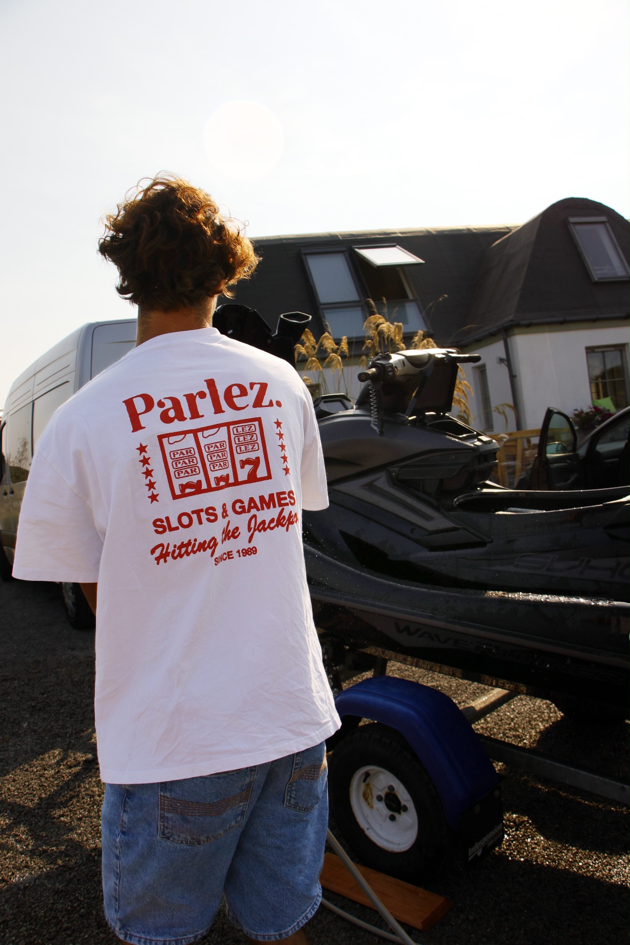 Rider looking over the jet ski on its trailer in low evening sun