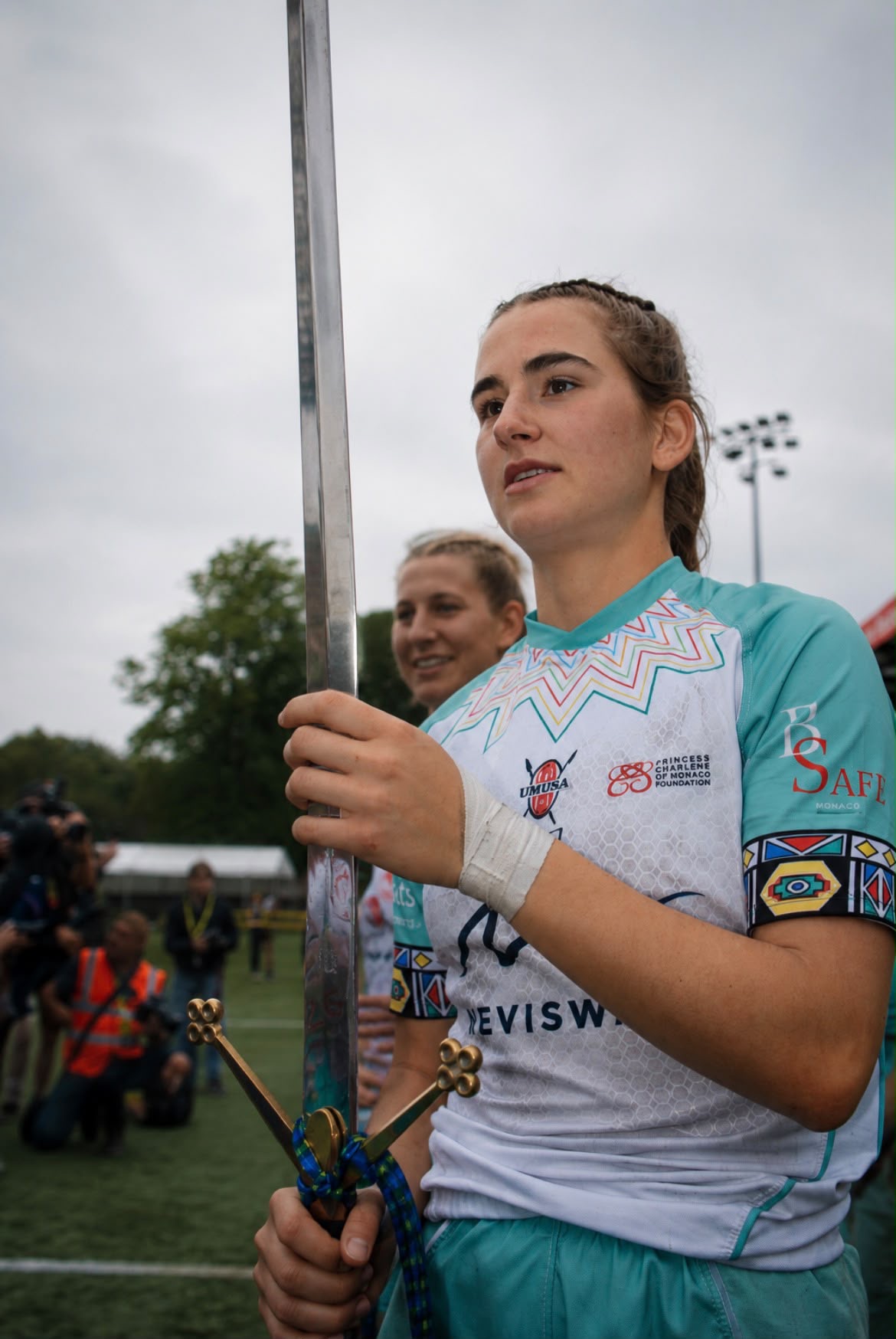 Sevens player looking off camera while holding the ceremonial sword