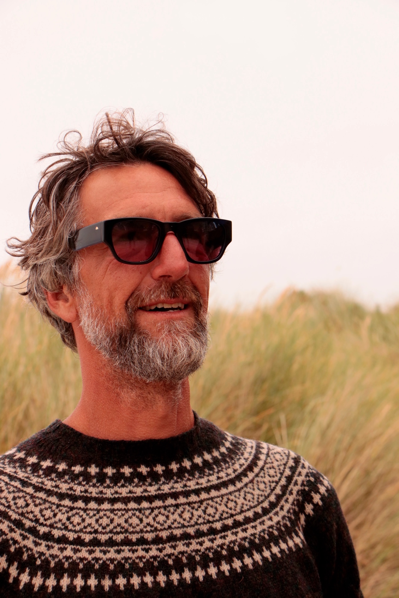 Portrait of a man wearing TENS sunglasses in the dune grass