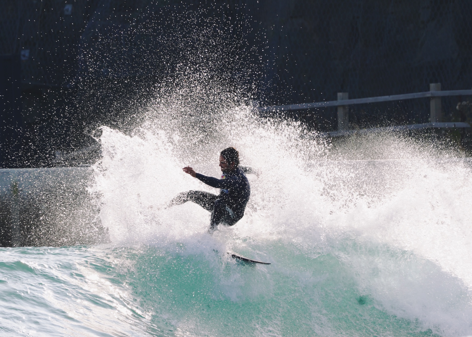 Surfer buried in spray through a powerful cutback