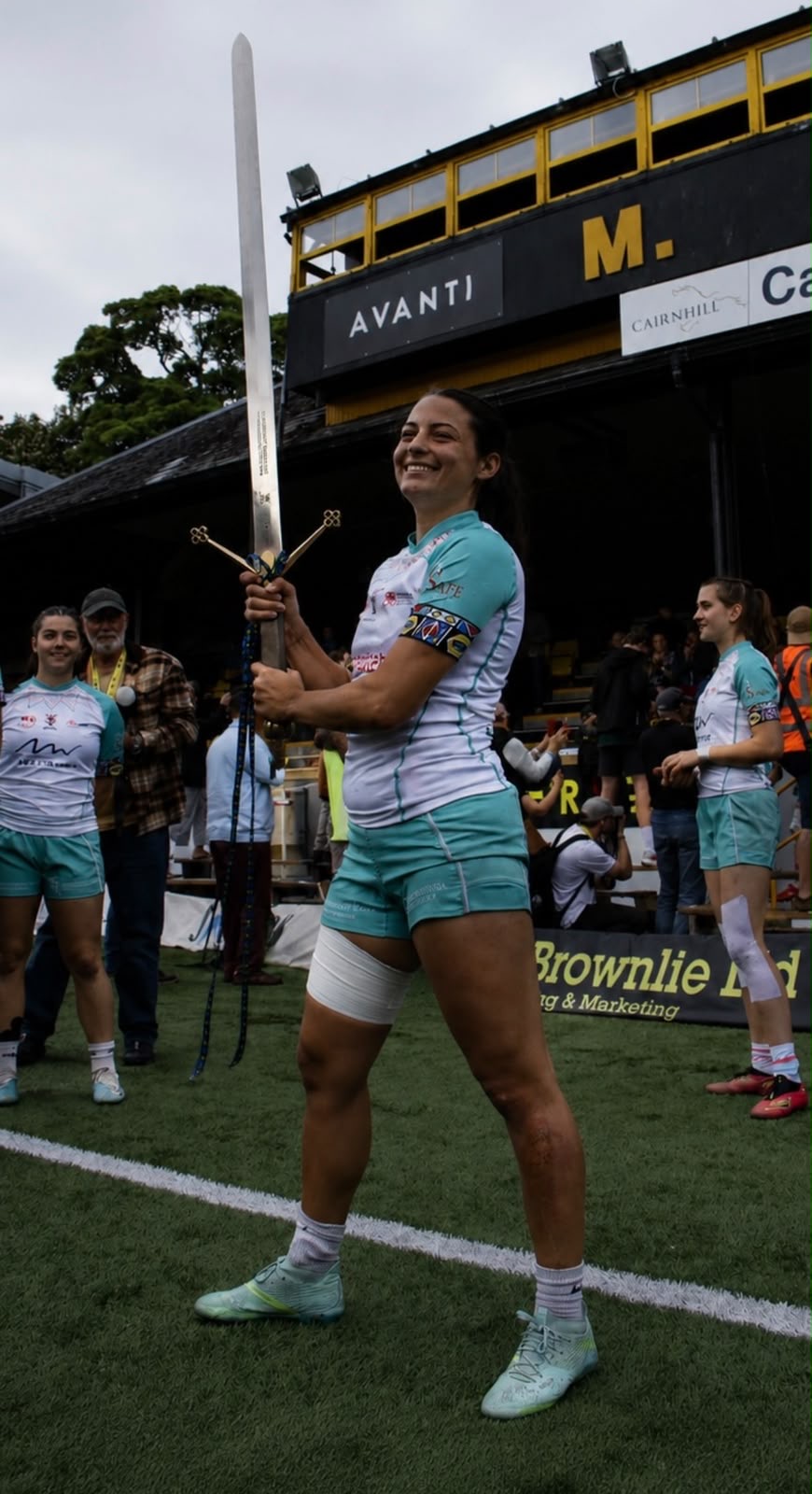 Sevens player standing on the pitch holding the ceremonial sword