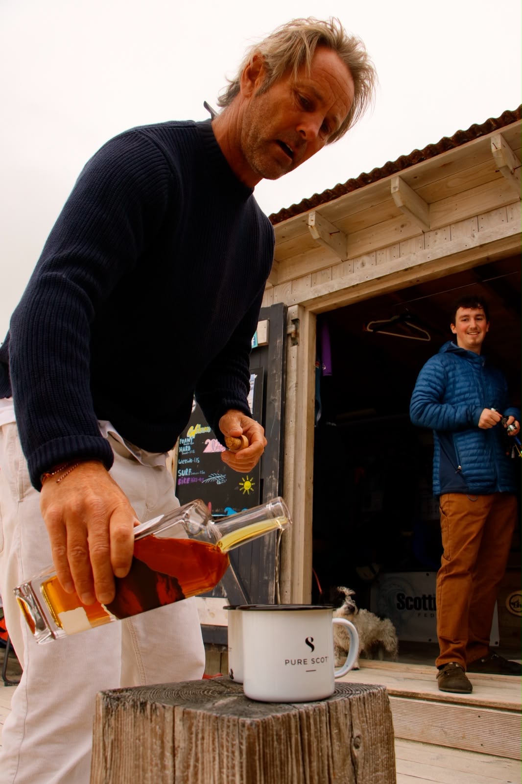 Pure Scot whisky poured into a branded enamel mug outside a beach surf shack