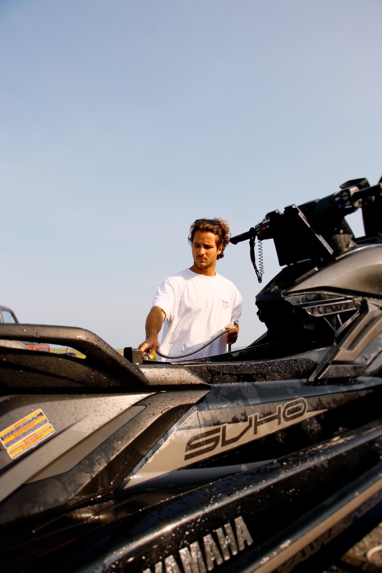 Rider rinsing down a jet ski on the trailer after a session