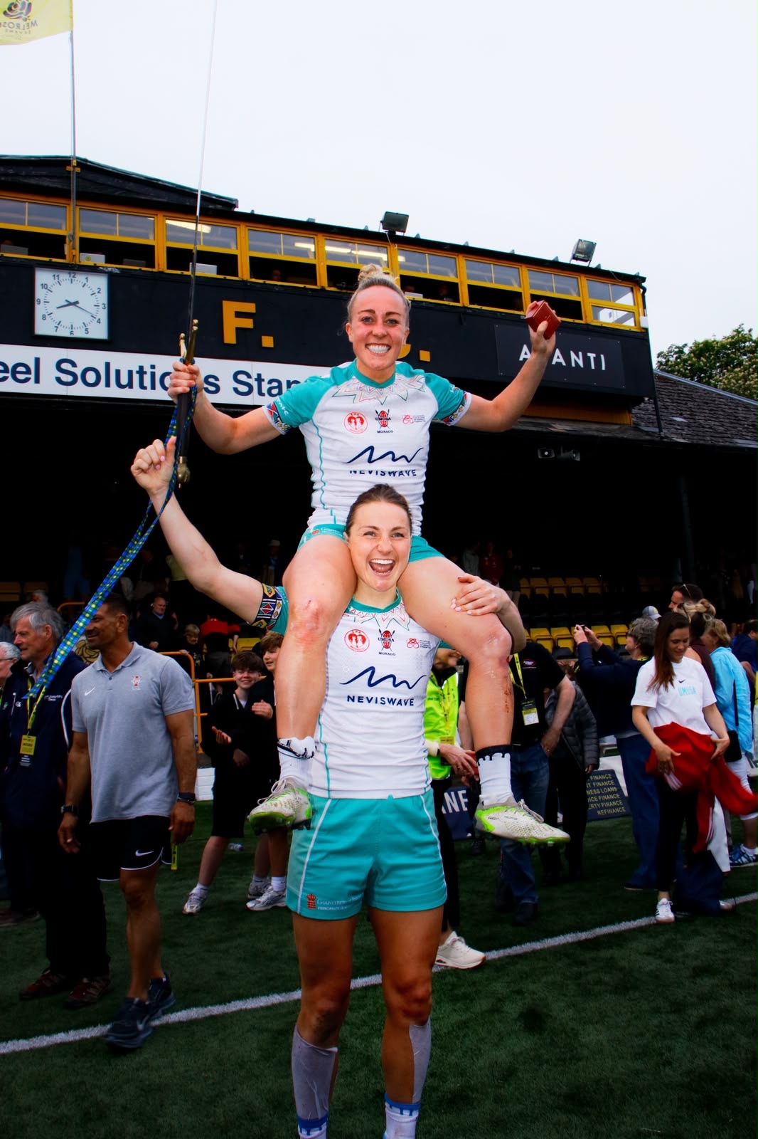 Sevens player chaired on a team-mate's shoulders holding the sword aloft